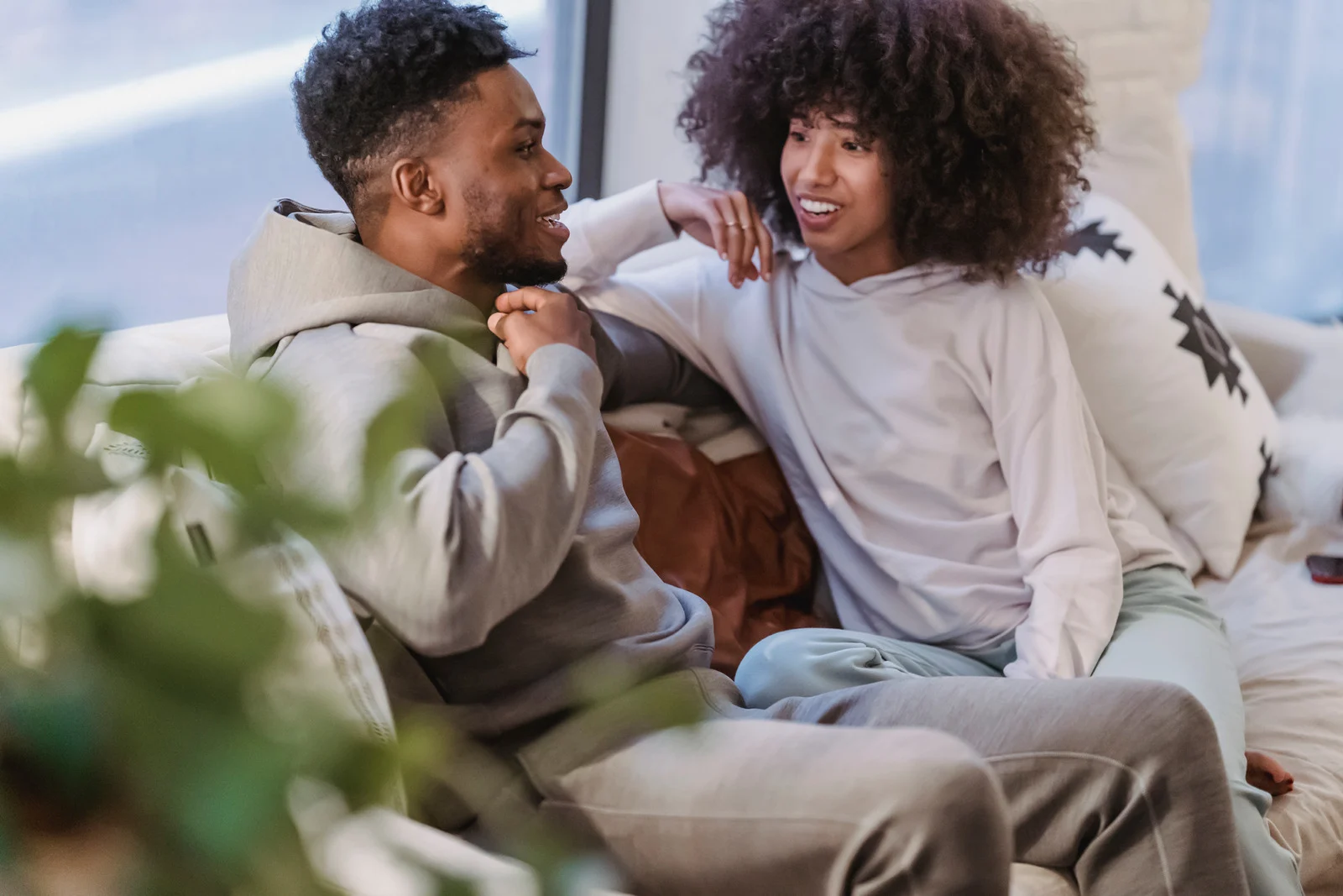 Couple sitting together and talking in a relaxed home setting.
