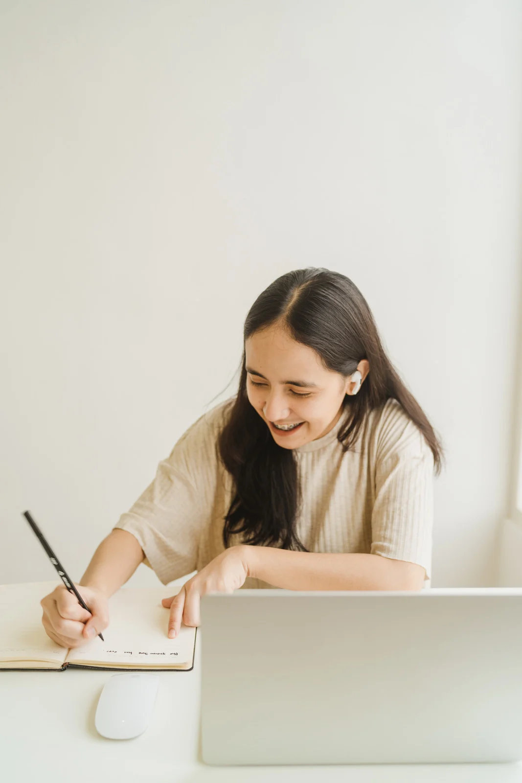 Person writing in a notebook in a calm, light-filled setting.
